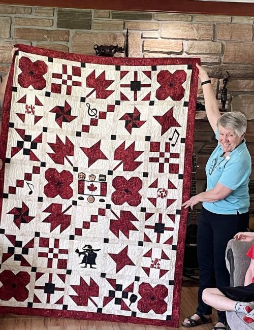 Lezley Zwaal displays the quilt created by the Rideau Lakes Westport Quilts for Valour group.
